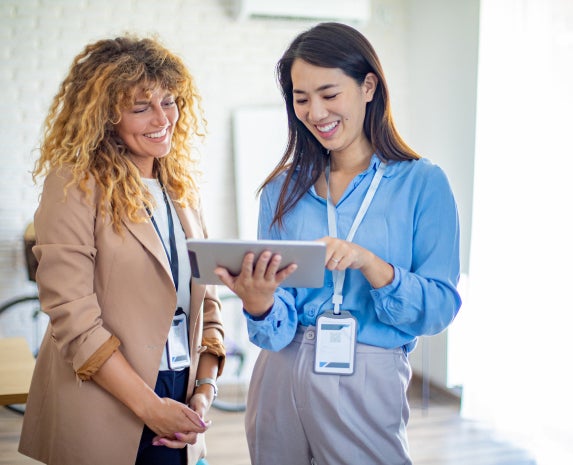 Two occupational therapists looking at an ipad